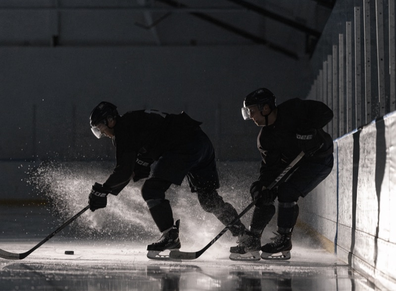 Zwei Eishockeyspieler im Zweikampf an der Bande
